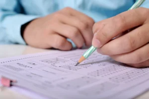 Filling out PMP exam application form with pencil
