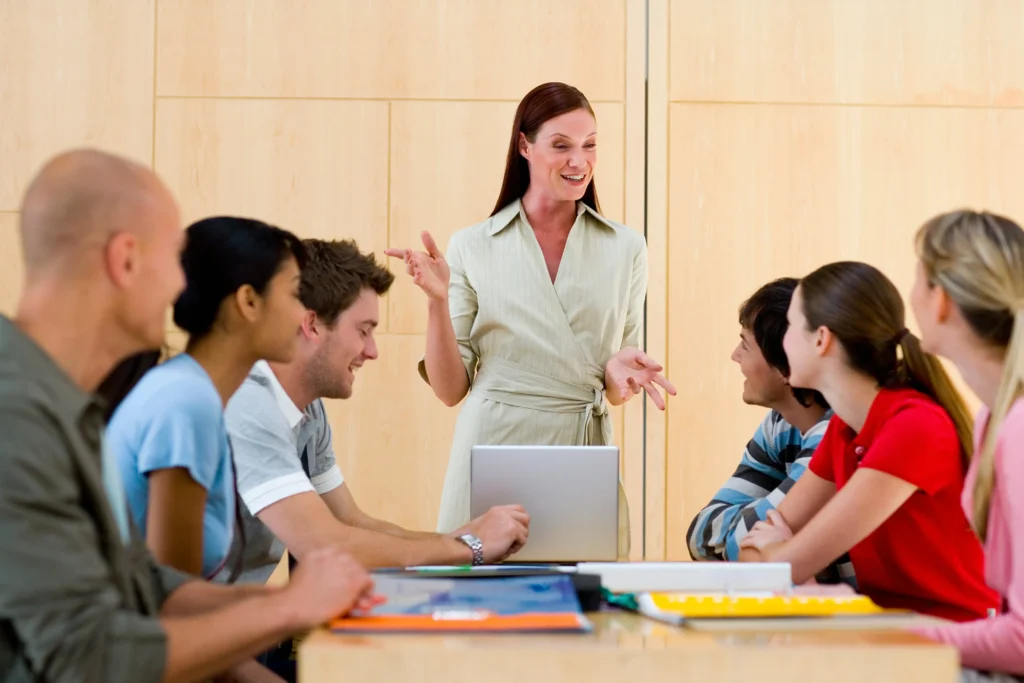  A group of working professionals listening to a classroom instructor, symbolizing the structure and accountability of live PMP training.